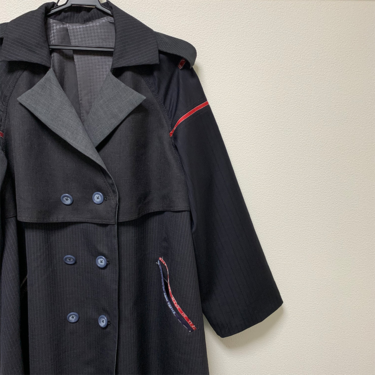 3年次の作品。数種類のスーツ地を組み合わせたコートを制作。「ポケットや袖のところに生地の耳を使用しました。赤いラインが映えて、よりデザイン性がアップしたかなと思います」